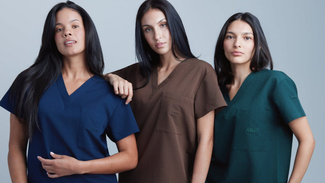 Three women wearing different colored scrubs against a gray background